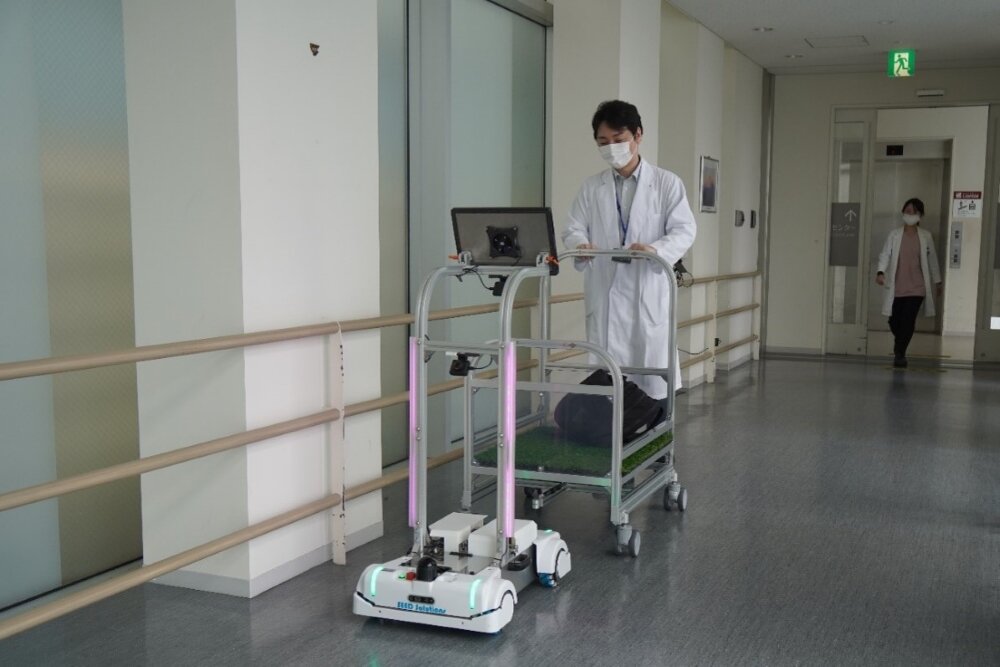 THKの自律搬送ロボットとカートをエレベーター降口付近で連結している様子
